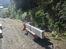 小型運搬車で石を一本ずつ運びます