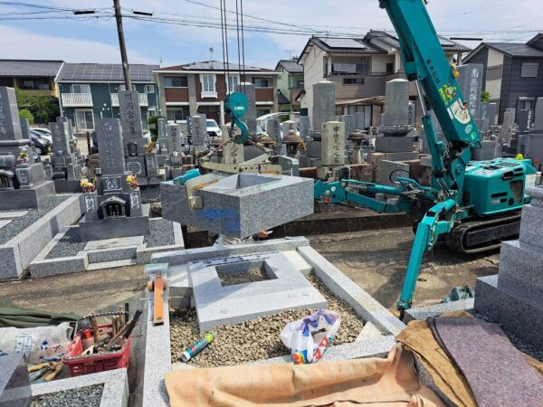 自社工場で事前に接着したお墓の四ツ石を小型クレーンで施工