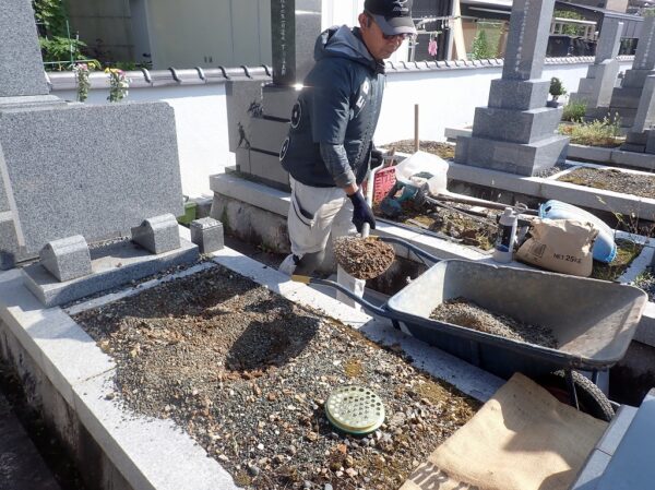巻石の補強に向けて墓所内の土を掘り出す作業